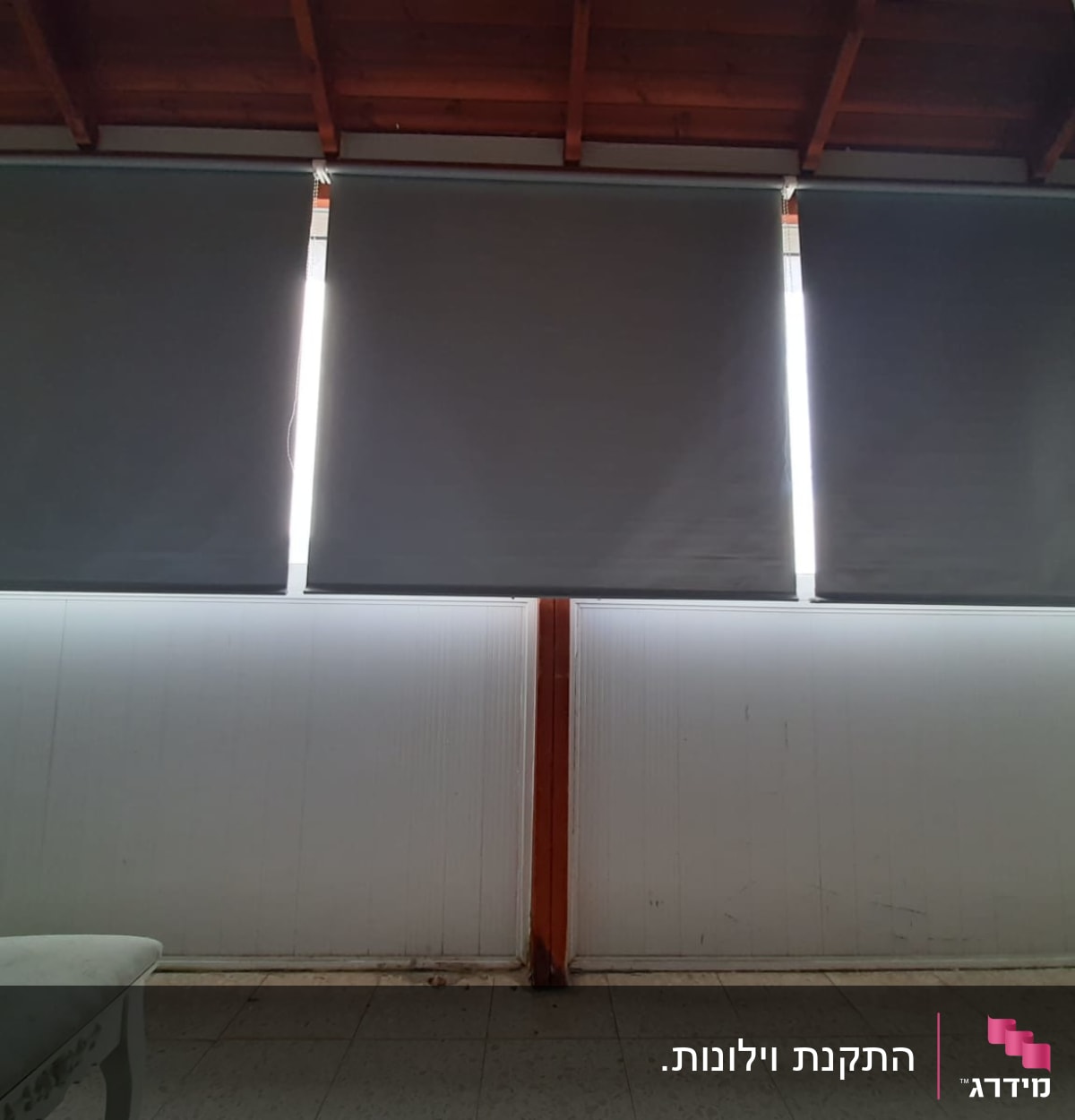 תריסים אפורים מותקנים על חלון גדול